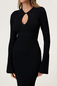 Woman wearing the knitted Basel maxi dress in black, featuring a cutout design at chest area and long, flared sleeves. thumbnail image