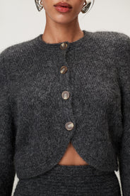 Woman wearing a Cessole cardigan in a gray textured knit, Adoore signature buttons, wide sleeves and cropped fit. thumbnail image