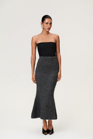 Woman wearing a Cessole midi skirt in dark grey. The skirt features a structured knit, midi length, zipper on the side, curved cutline in the waist, and softly flared bottom. thumbnail image