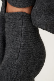 Woman wearing a Cessole midi skirt in dark grey. The skirt features a structured knit, midi length, zipper on the side, curved cutline in the waist, and softly flared bottom. thumbnail image