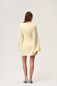 A model wearing a pastel yellow mini dress with wide balloon sleeves, a V-shaped neckline, and buttons along the front. The dress has a hidden zipper in the back and is fully lined. thumbnail image