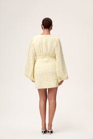 A model wearing a pastel yellow mini dress with wide balloon sleeves, a V-shaped neckline, and buttons along the front. The dress has a hidden zipper in the back and is fully lined. thumbnail image