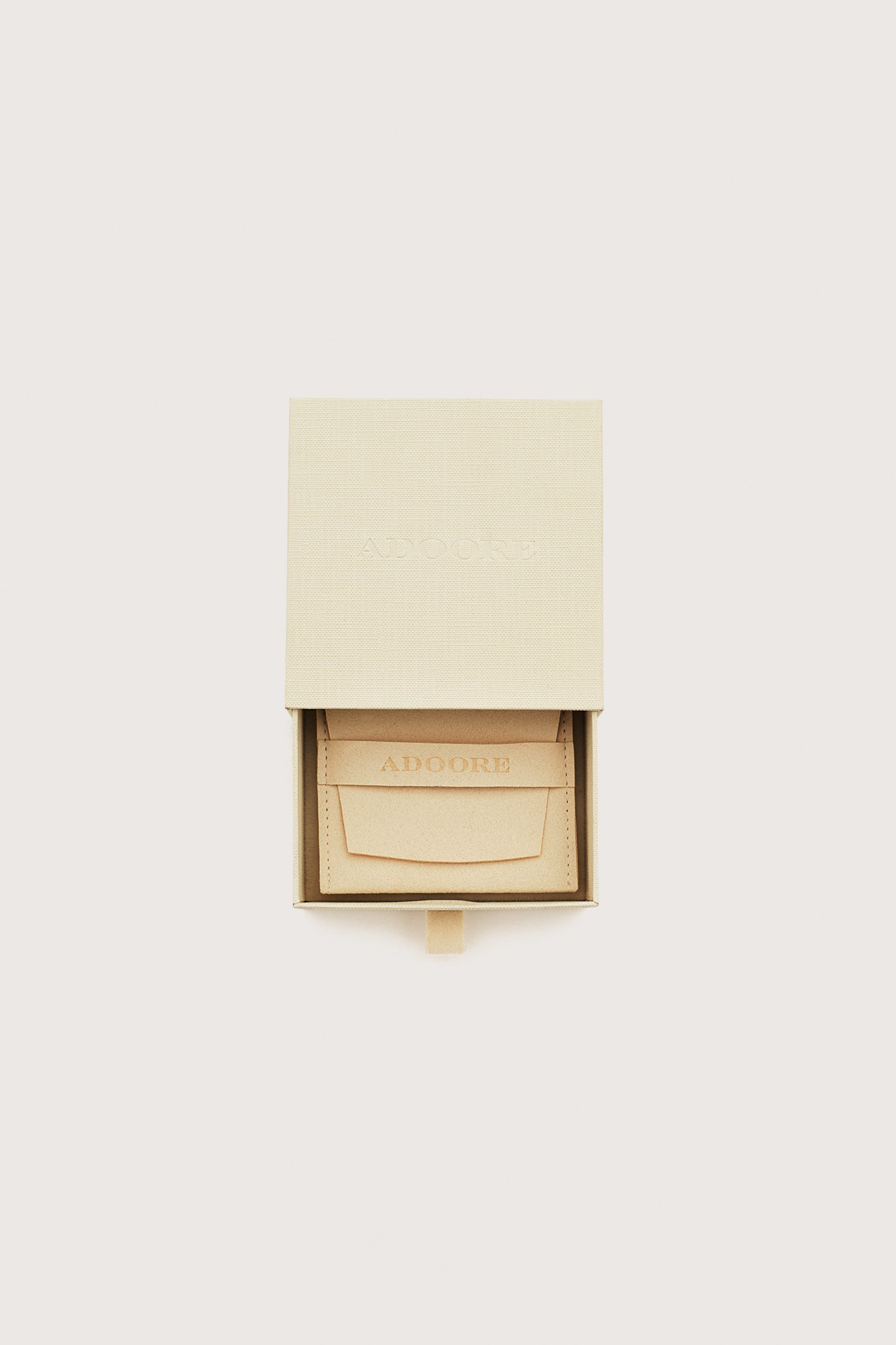 Beige jewelry box with 'ADOORE' branding on a white background image