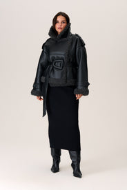 A model wearing a black Manchester cropped jacket with oversized fit, faux shearling lining, side pockets, and a belt with a D-shaped buckle. thumbnail image