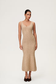 Woman wearing the Merano maxi dress in beige melange, a sleek, figure-flattering style with delicate singlet straps, a deep V-neckline, and an hourglass fit. thumbnail image