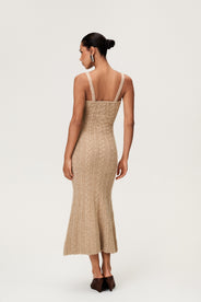 Woman wearing the Merano maxi dress in beige melange, a sleek, figure-flattering style with delicate singlet straps, a deep V-neckline, and an hourglass fit. thumbnail image