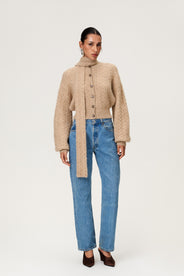 Woman wearing the Merano scarf in beige melange, styled with Merano cardigan in beige melange. The scarf is a lightweight knit with a soft texture, perfect for year-round layering. thumbnail image