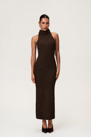 Woman wearing the Montreux maxi dress in brown melange with a voluminous halterneck, light wool-blend knit, and asymmetric panel details that flatter the figure. thumbnail image
