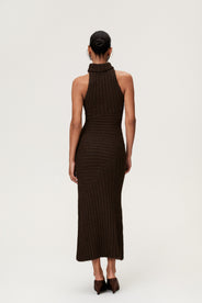 Woman wearing the Montreux maxi dress in brown melange with a voluminous halterneck, light wool-blend knit, and asymmetric panel details that flatter the figure. thumbnail image