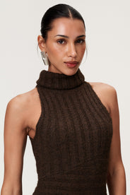 Woman wearing the Montreux maxi dress in brown melange with a voluminous halterneck, light wool-blend knit, and asymmetric panel details that flatter the figure. thumbnail image