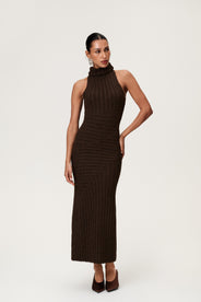 Woman wearing the Montreux maxi dress in brown melange with a voluminous halterneck, light wool-blend knit, and asymmetric panel details that flatter the figure. thumbnail image