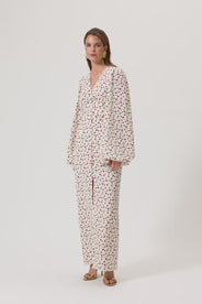 A model wearing Positano dress, size 34, a red cherry print maxi dress with long sleeves, a V-neck collar, and front slits. thumbnail image